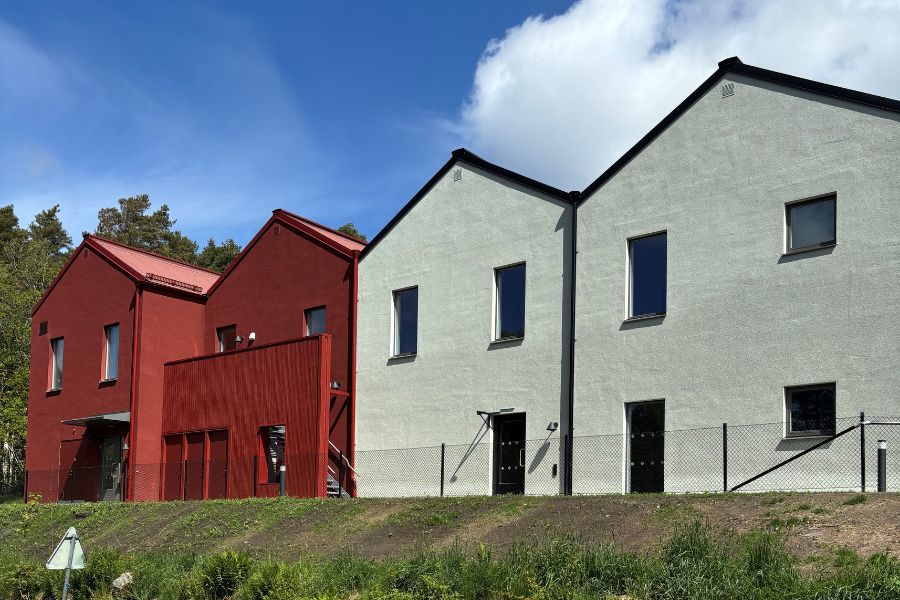 Byggnadsställningar runt pågående byggprojekt omgivna av träd och grönska