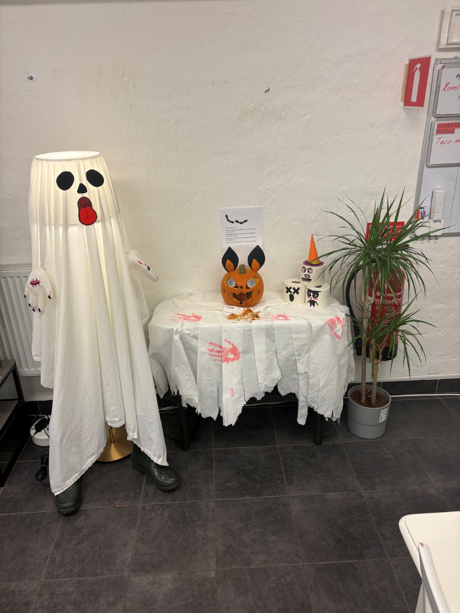 En lampa omgjord till spöke, på bord bredvid läskigt utkarvad pumpa som ser ut som läskig kanin. Spår av blodiga händer på duken.