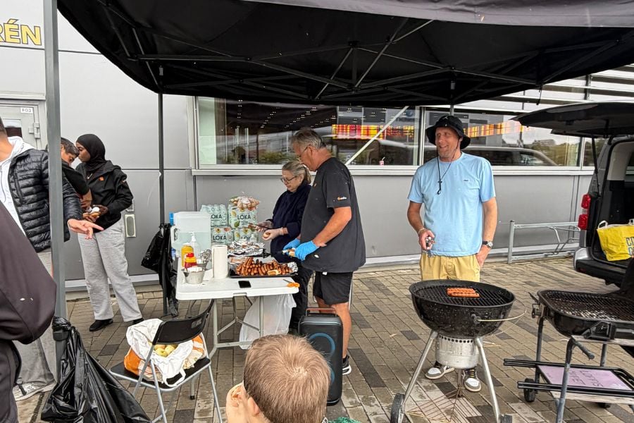 Ett tält utomhus som hyser människor som grillar korv