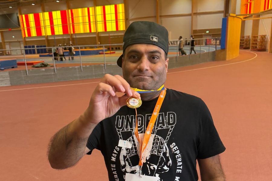 En glad deltagare visar stolt upp sin medalj
