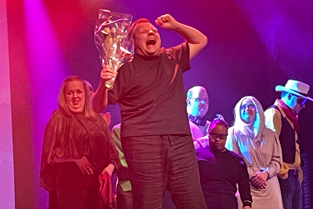 Max som vann, st&aring;r p&aring; scenen med lyfta armar och blommor i handen