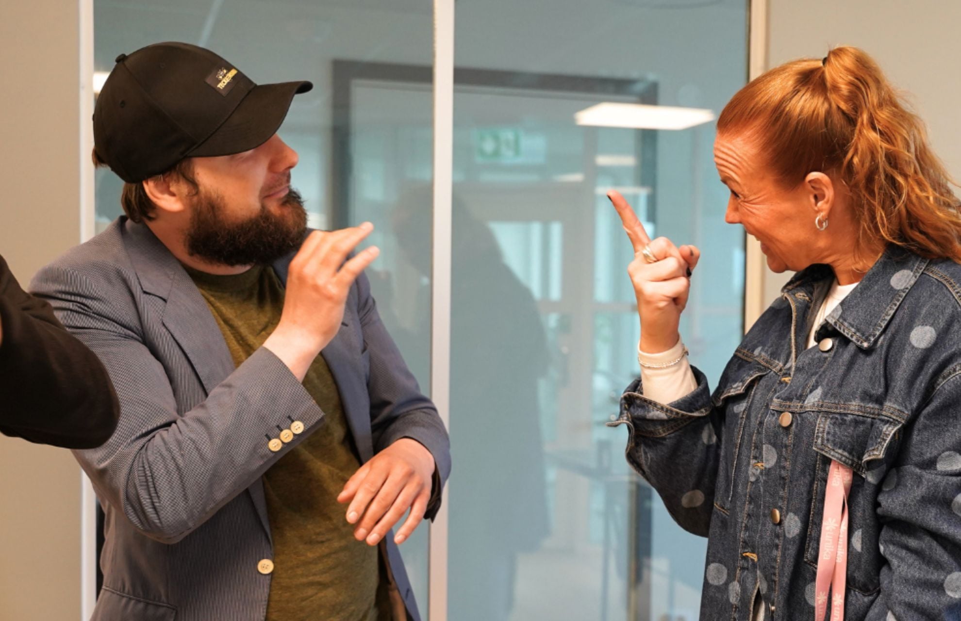 Oleg och Linnea som arbetar på Unika Bergshamra pratar teckenspråk med varandra